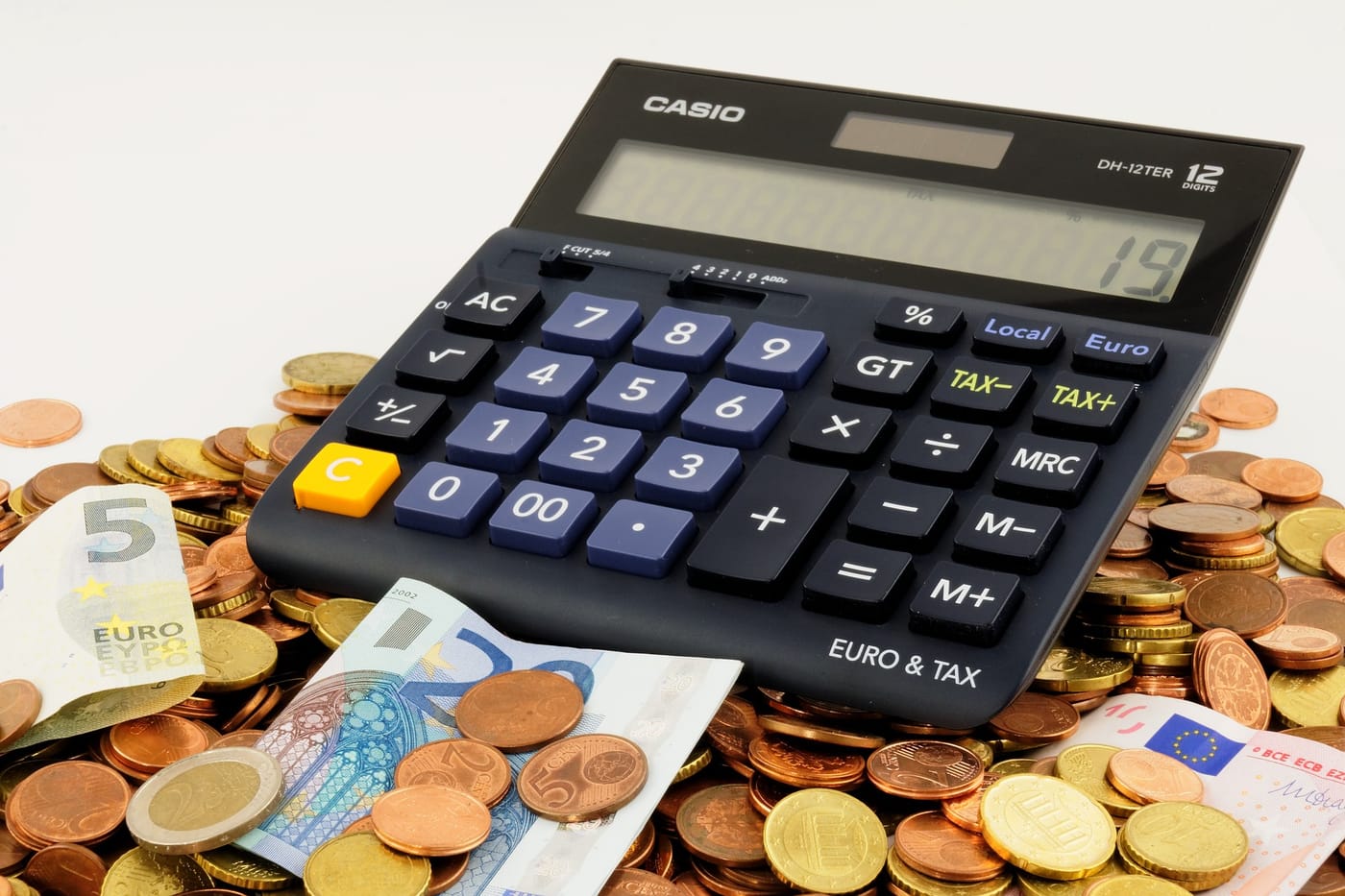 a photo with a calculator and some money and coins around